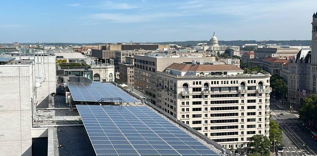 Solar array along a rooftop with downtown Washington beyond