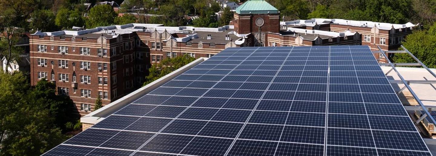 Solar canopy at 3801 Connecticut Ave. with a neighboring brick building and treetops behind