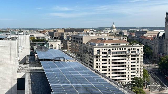 Solar array along a rooftop with downtown Washington beyond