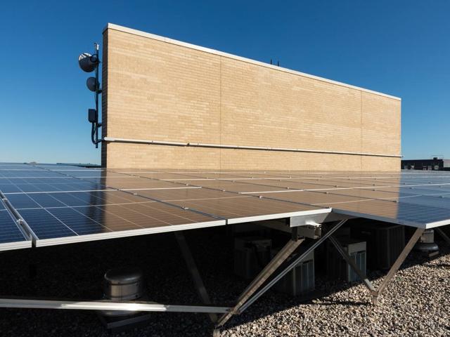 Solar canopy on W-shaped supports beside the brick penthouse at 1441 Rhode Island Ave.