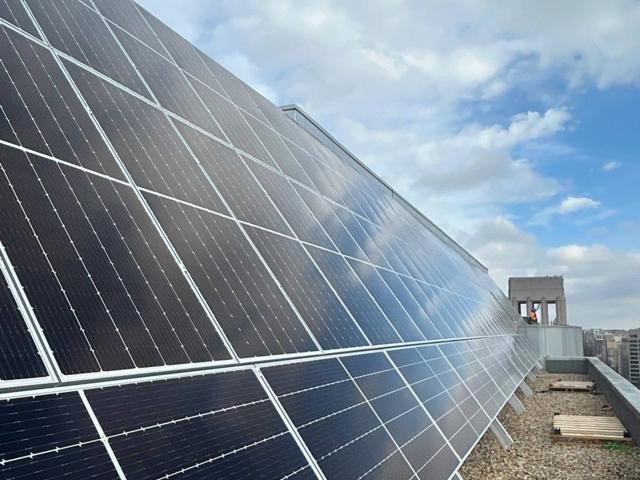 High tilt solar array along the parapet at 1909 Aurora Energy
