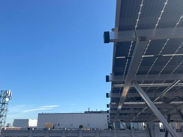 High tilt solar array at 1909 Aurora Energy, seen from below against the sky