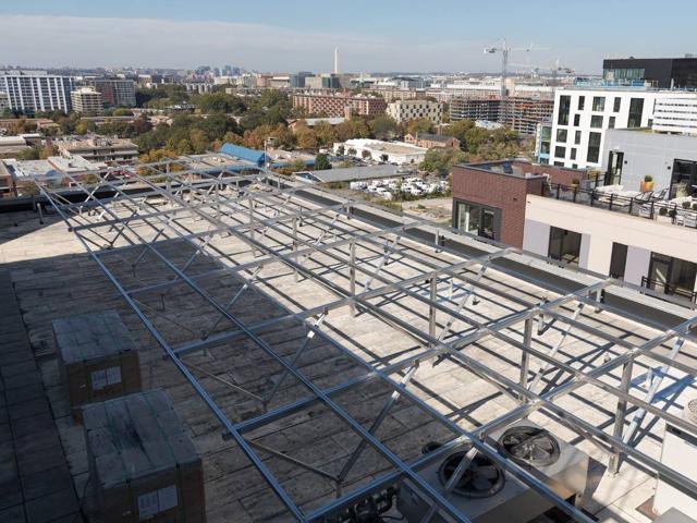 Racking frame assembled over rooftop equipment at 20 M Street, with the city skyline behind
