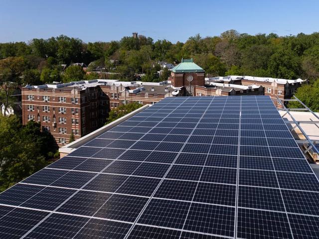 Solar canopy at 3801 Connecticut Ave. with a neighboring brick building and treetops behind