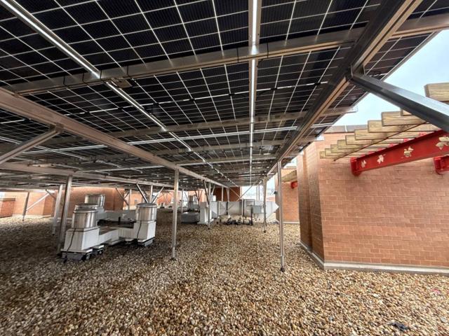 Rooftop equipment under the solar canopy beside the brick penthouse at 616