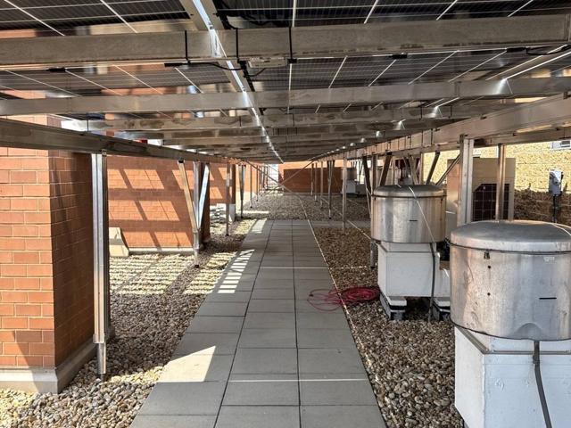 Paved walkway and exhaust fans beneath the solar canopy at 616