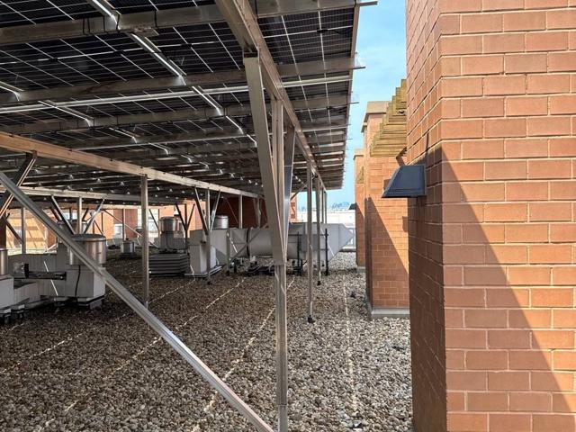 Solar canopy supports beside a brick wall at 616