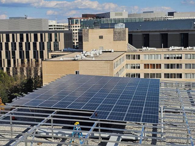 Solar canopy at 925 during installation, seen past a cooling tower