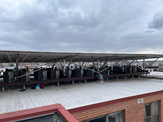 Solar canopy above the line of condensers at Randolph Towers, seen across the roof