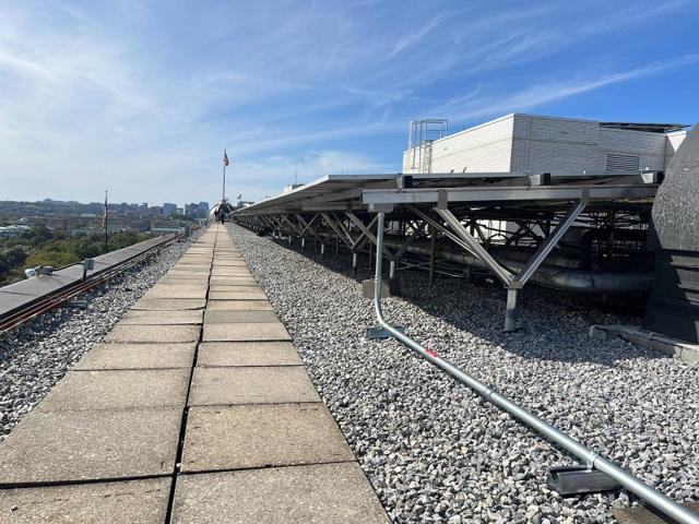 Low flush mount solar racking beside a roof walkway