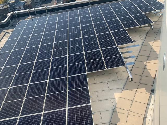Aerial view of a solar array on a residential building roof