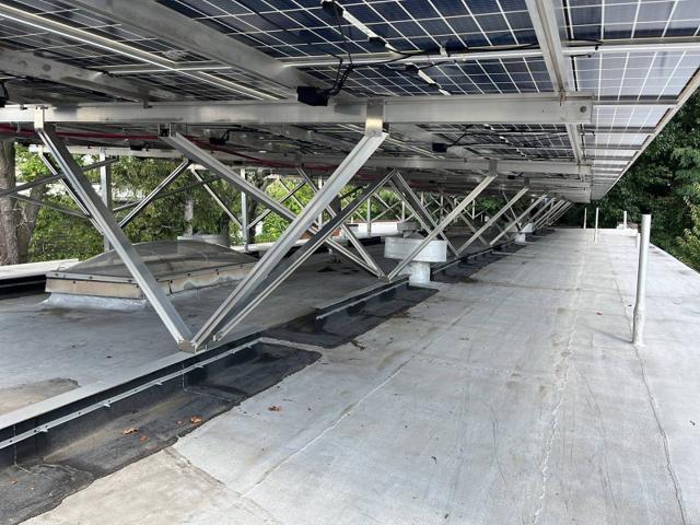 W System bracing beneath a solar canopy on a white roof