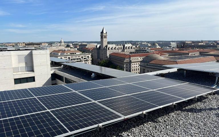 Rooftop solar array with the Old Post Office tower in the distance