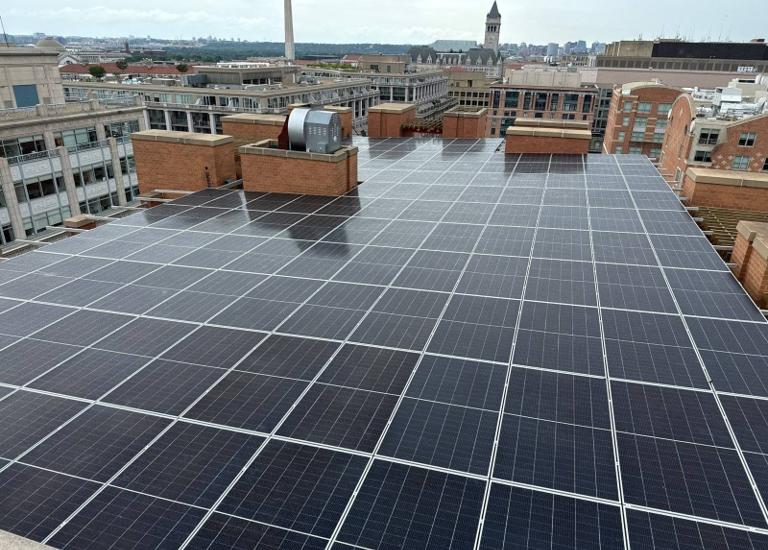 Solar canopy on the roof at 616, with the Old Post Office tower and Washington Monument beyond