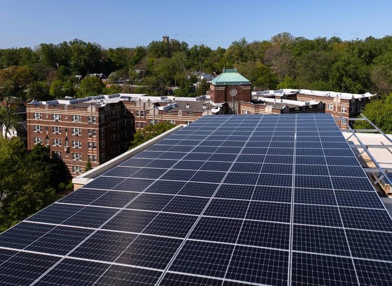 Solar canopy at 3801 Connecticut Ave. with a neighboring brick building and treetops behind