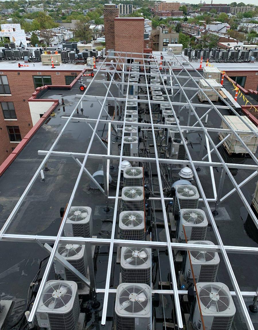 Aerial view of the racking frame over rows of rooftop condensers at Randolph Towers, before the panels